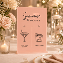 Load image into Gallery viewer, Blush pink acrylic signature drinks sign with black vinyl lettering displayed on a wedding table with roses, candles and glassware.