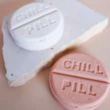 Load image into Gallery viewer, Pink and white Chill Pill bath bombs handmade in Perth, Western Australia, displayed on a natural stone tray with a soft neutral background.