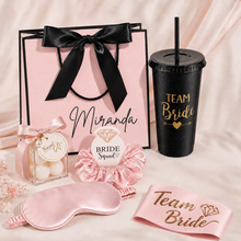 Load image into Gallery viewer, Personalised bridesmaid proposal gift bag with Team Bride cup, satin eye mask, Bride Squad scrunchie, sash and mini sweet gift box, styled as an affordable bridal party gift.
