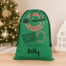 Load image into Gallery viewer, Large green personalised Santa sack with custom child’s name, styled with Christmas gifts and festive tree decorations.
