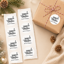 Load image into Gallery viewer, Personalised Merry Christmas stickers on rough sticker strips beside kraft wrapped Christmas gift and festive pine decor.
