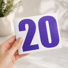Load image into Gallery viewer, Hand holding a white backing card with bold purple number 20 vinyl bin decals, styled in a clean professional product photo with a soft neutral background.
