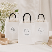 Load image into Gallery viewer, Personalised wedding thank you stickers on white favour gift bags with black handles and neutral wedding styling.
