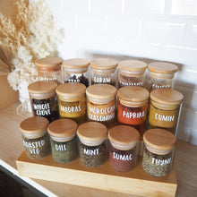 Load image into Gallery viewer, An organized spice rack filled with spice jars sporting beautiful custom labels.

